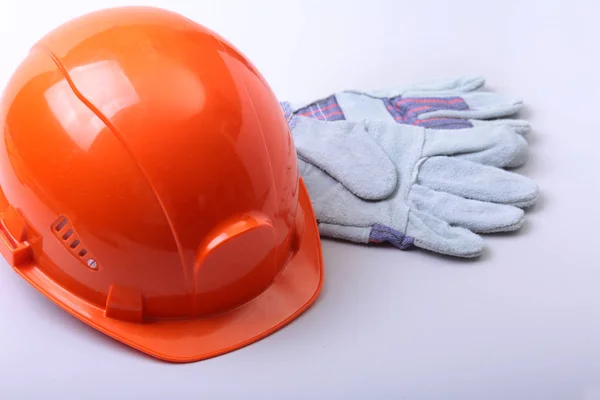 Oranžový tvrdý klobouk, brýle a bezpečnostní rukavice na bílém pozadí. — Stock fotografie