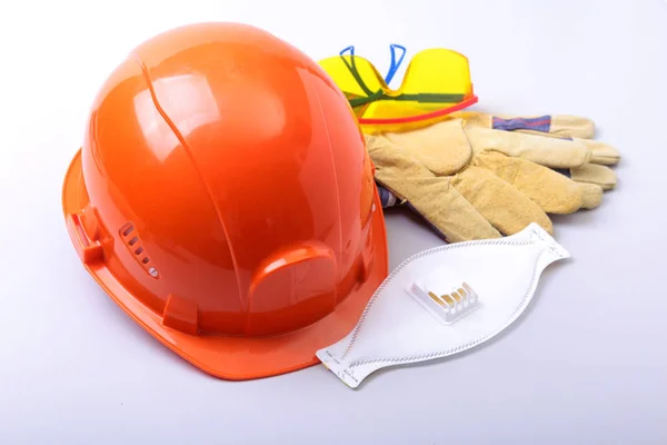 Oranžová čepice, brýle, ochranné masky, respirátor a ochranné rukavice na bílém pozadí. — Stock fotografie