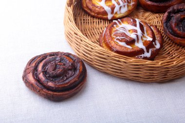 Ev yapımı taze pişmiş tatlı çörek ya da tatlı tarçın ile bir hasır sepet rulo.