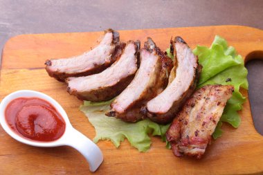 marul yaprakları, sıcak biber ve sos ahşap kesme tahtası üzerinde mangalda kaburga ızgara.