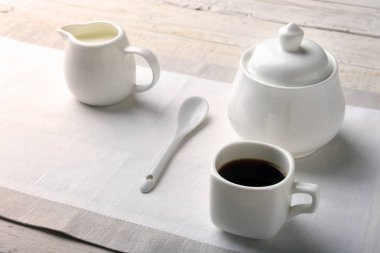 Bir fincan sıcak kahve espresso, kahve çekirdekleri, sürahi süt ve şeker kopya alanı için beyaz arka plan üzerine bir kase. Kahve kavramı.