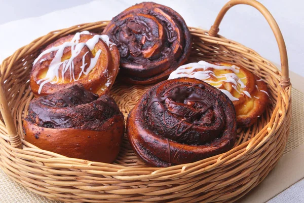 Bollo dulce casero recién horneado o rollos dulces con canela en una canasta de mimbre . — Foto de Stock