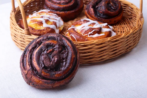 Ev yapımı taze pişmiş tatlı çörek ya da tatlı tarçın ile bir hasır sepet rulo.
