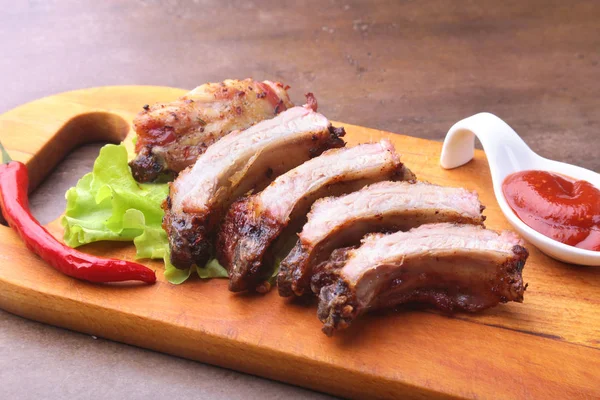 marul yaprakları, sıcak biber ve sos ahşap kesme tahtası üzerinde mangalda kaburga ızgara.