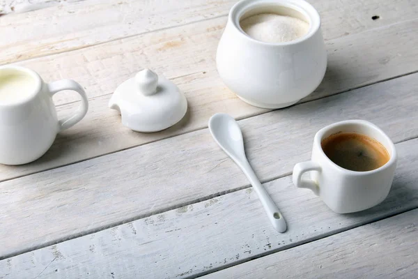 Bir fincan sıcak kahve espresso, kahve çekirdekleri, sürahi süt ve şeker kopya alanı için beyaz arka plan üzerine bir kase. Kahve kavramı.