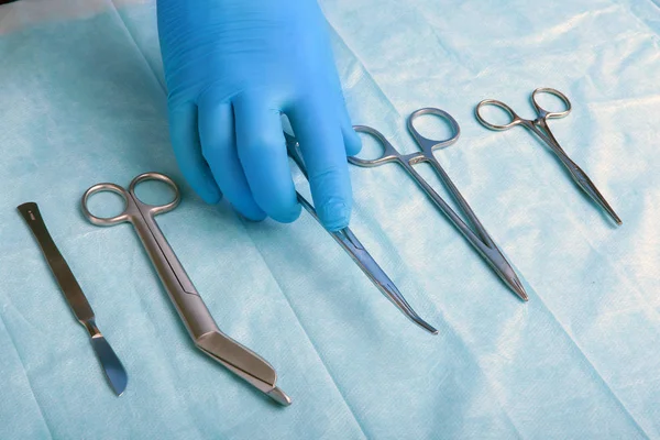 Bilder av steriliserte kirurgiske instrumenter med en hånd som griper et verktøy  , – stockfoto