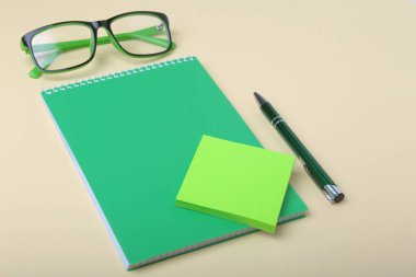 İş amaçlı aksesuarları üstünde okul sırası: Not Defteri, günlük, dolma kalem, gözlük. Makro bulanıklık ve yumuşak odak ile.