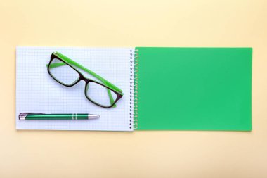 İş amaçlı aksesuarları üstünde okul sırası: Not Defteri, günlük, dolma kalem, gözlük. Makro bulanıklık ve yumuşak odak ile.