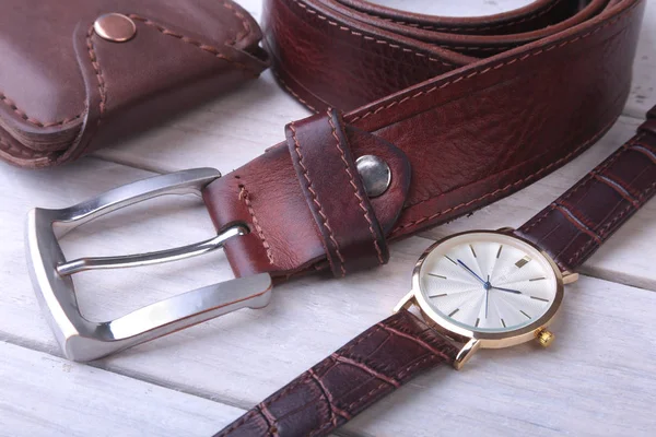 Accesorios para hombre para negocios y rekreation. Cinturón de cuero, billetera, reloj y pipa de fumar sobre fondo de madera.. . —  Fotos de Stock
