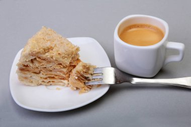 Ev yapımı Napoleon puf pasta plaka ve geleneksel espresso kahve beyaz arka plan üzerinde izole. yakın çekim.