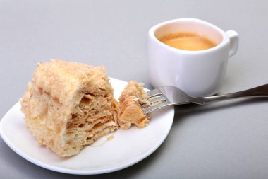 Ev yapımı Napoleon puf pasta plaka ve geleneksel espresso kahve beyaz arka plan üzerinde izole. yakın çekim.