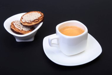 Klasik espresso ile ev yapımı kek siyah arka plan üzerine beyaz Kupası'nda. Seçici odak.