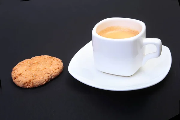 Café expresso clássico em xícara branca com bolo caseiro em fundo preto. Foco seletivo . — Fotografia de Stock