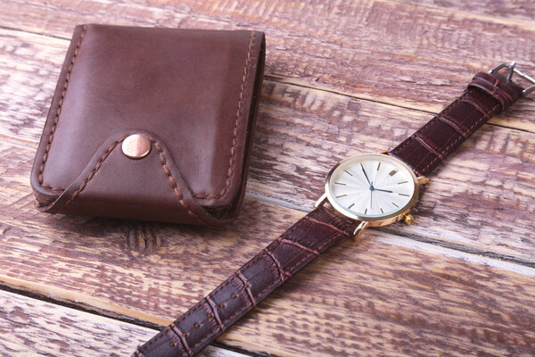 Mens accessories with brown leather wallet, belt and watch.