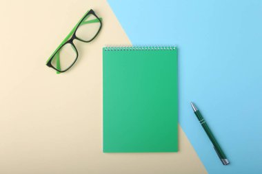 İş amaçlı aksesuarları üstünde okul sırası: Not Defteri, günlük, dolma kalem, gözlük. Makro bulanıklık ve yumuşak odak ile.