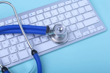 Notebook klavye ve yeşil gözlük yalan bir mavi stetoskop closeup. seçici odak.