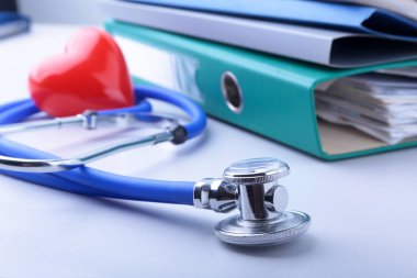 Klasör dosyası, stetoskop, kırmızı kalp ve beyaz arka plan üzerinde izole Rx reçete kitaplar.