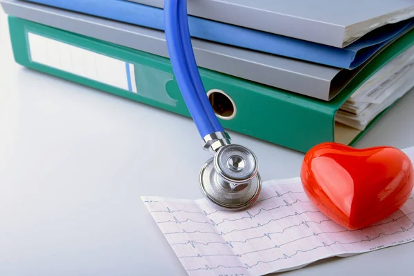 Libretas carpeta archivo, estetoscopio, corazón rojo y prescripción RX aislado sobre fondo blanco . — Foto de Stock