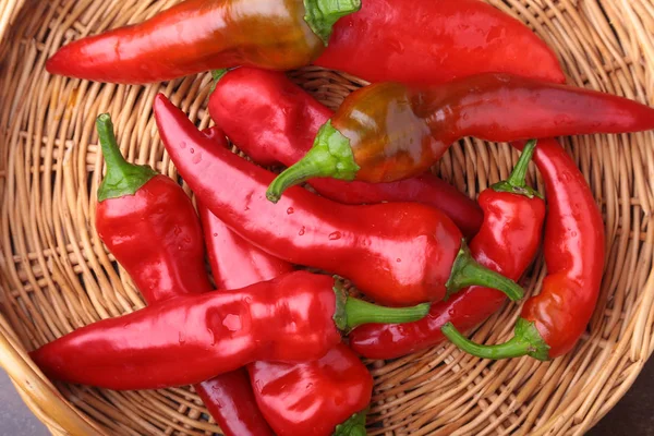 Cesta de mimbre llena de chiles rojos frescos . — Foto de Stock