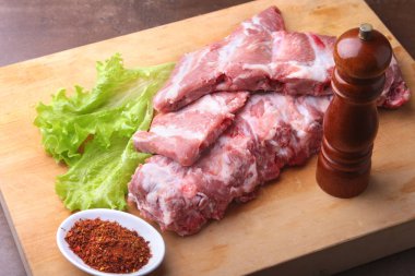 Tuz, biber ve baharat değirmeni ile bir rustik kesme tahtası üzerinde ham kaburga. kopya alanı. Üstten Görünüm.