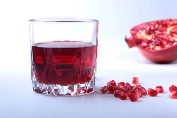 Vidrio con jugo de granada Semillas de granada y hermosa granada madura sobre fondo blanco con lugar para espacio de copia . — Foto de Stock