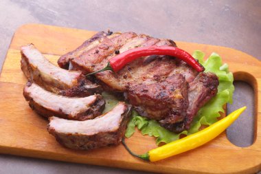 marul yaprakları, sıcak biber ve sos ahşap kesme tahtası üzerinde mangalda kaburga ızgara.