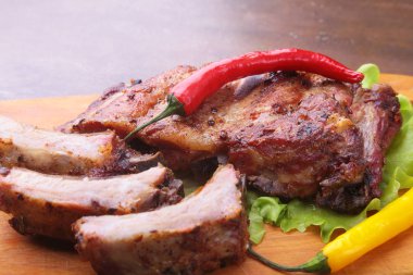 marul yaprakları, sıcak biber ve sos ahşap kesme tahtası üzerinde mangalda kaburga ızgara.