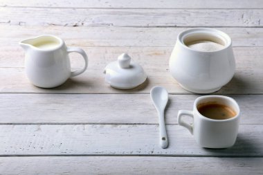 Bir fincan sıcak kahve espresso, kahve çekirdekleri, sürahi süt ve şeker kopya alanı için beyaz arka plan üzerine bir kase. Kahve kavramı.