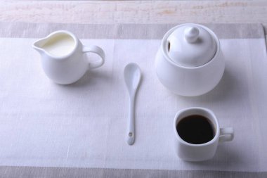 Bir fincan sıcak kahve espresso, kahve çekirdekleri, sürahi süt ve şeker kopya alanı için beyaz arka plan üzerine bir kase. Kahve kavramı.