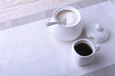 Bir fincan sıcak kahve espresso, kahve çekirdekleri, sürahi süt ve şeker kopya alanı için beyaz arka plan üzerine bir kase. Kahve kavramı.