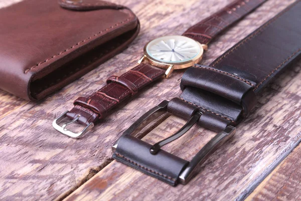 Set of mens accessories for the business with leather belt, wallet, watch and smoking pipe on a wooden background. The concept of fashion and travel. — Stock Photo, Image