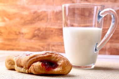 Paskalya kahvaltı reçel ile geleneksel hot cross bun ve süt ile cam ile. Yukarıdan ahşap tablo.