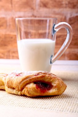 Paskalya kahvaltı reçel ile geleneksel hot cross bun ve süt ile cam ile. Yukarıdan ahşap tablo.