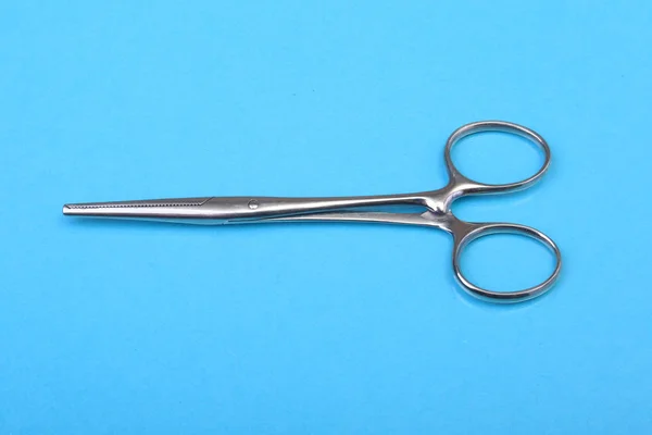 Nära upp kirurgiska instrument och verktyg på blå spegel bakgrund. Selektivt fokus. — Stockfoto