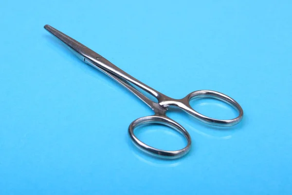 Close Up chirurgicznych instrumentów i narzędzi na tle niebieskie lustro. Selektywny fokus. — Zdjęcie stockowe