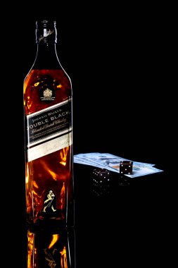 Grodno, Belarus, tercihine 04, 2018, Johnnie Walker Çift Kişilik Black label harmanlanmış scotch viski, ahşap dices ve para. Şeytanlar kemik siyah ayna masada.