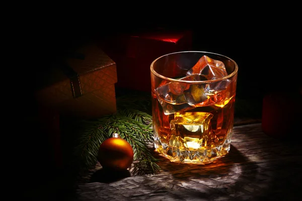 Glass with cognac or whiskey, Christmas balls and candles. New Years tree, balls and glass with alcohol. — Stock Photo, Image