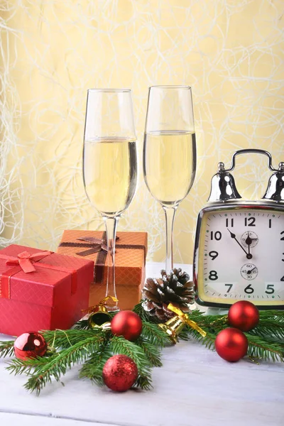 Decoraciones de Año Nuevo o Navidad con copas de vino, cajas de regalo, velas y bolas. Tarjeta de felicitación. Enfoque selectivo, espacio de copia . — Foto de Stock