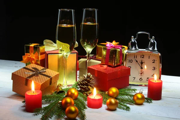 Nieuwjaar of Kerst decoraties met glazen wijn, geschenkverpakkingen, kaarsen en ballen. wenskaart. Selectieve aandacht, kopie ruimte. — Stockfoto