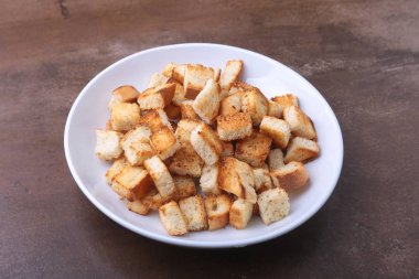 Lezzetli çıtır kruton, beyaz tabak içinde ekmek kırıntıları. hazır yemek pişirmek için.