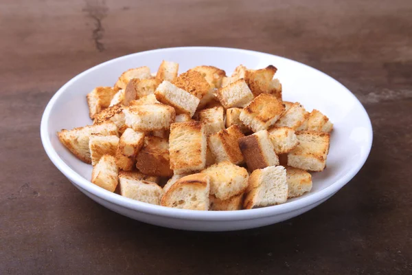 Delicious crispy croutons, crumbs of bread in white plate. ready for cooking. — Stock Photo, Image