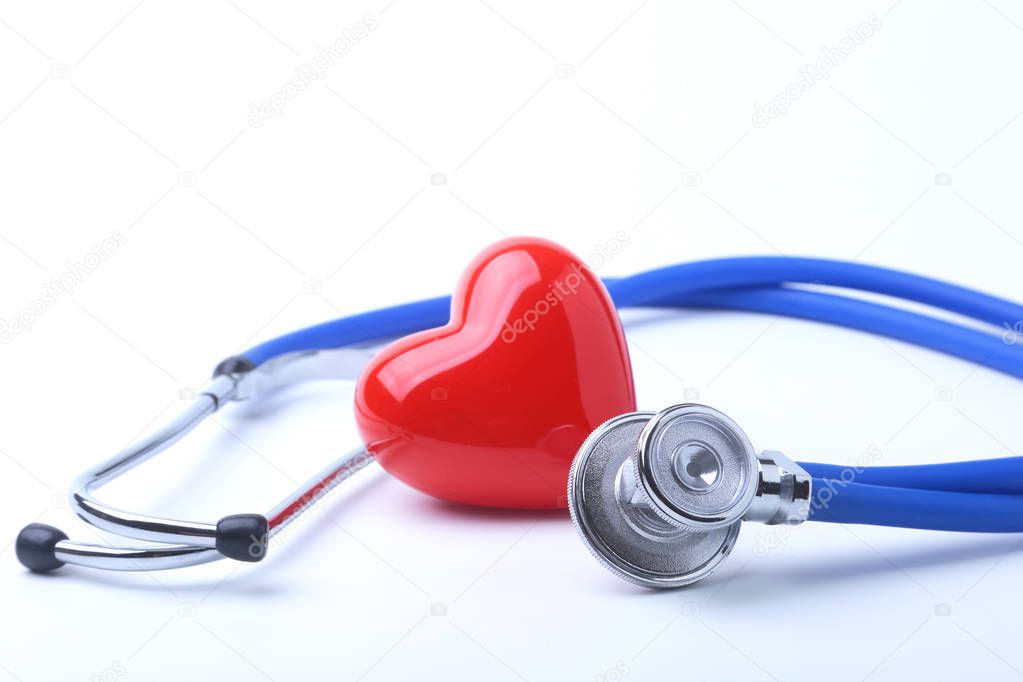 Medical stethoscope and red heart isolated on white.