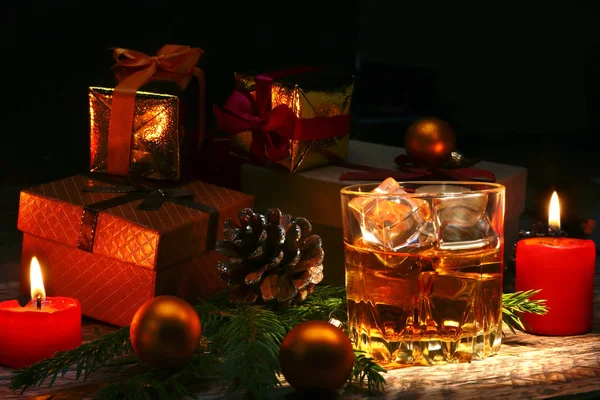 Konyak ya da bardakta viski. Noel topları, hediye kutuları ve mumlar. Yılbaşı ağacı, toplar ve alkol ile cam