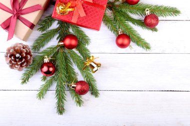 Noel ağacı ve koniler, yeni yıl renkli topları şerit ve hediye kutusunda beyaz tahta arka plan ile. Dekorasyon için mutlu tatiller. Uzay kopyalayın. Üstten görünüm