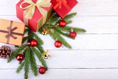 Noel ağacı ve koniler, yeni yıl renkli topları şerit ve hediye kutusunda beyaz tahta arka plan ile. Dekorasyon için mutlu tatiller. Uzay kopyalayın. Üstten görünüm