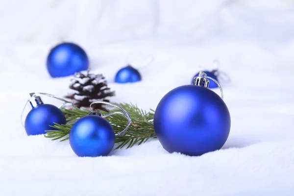 Merry Christmas background with blue balls, christmas tree on snow with snowflakes falling from a blue sky. Stock Image