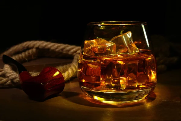 Whisky, cognac ou brandy avec glace dans les verres et pipe à fumer sur fond de bois rustique, espace de copie . — Photo