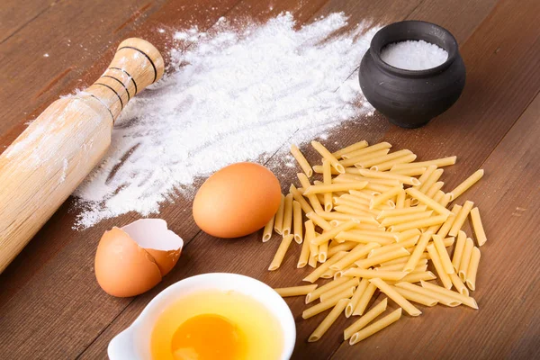 Egg, flour, salt ingredients for pasta penne bolognese. Cooking concept. Top view. — Stock Photo, Image