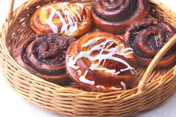 Bollo dulce casero recién horneado o rollos dulces con canela en una canasta de mimbre . — Foto de Stock