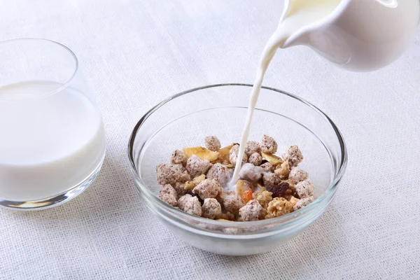 Desayuno saludable. Granola fresca, muesli con coco, manzana de plátano y nueces con leche en un tazón blanco sobre fondo textil. Vista superior . —  Fotos de Stock